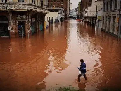 Ein Mann watet in Porto Alegre im brasilianischen Bundesstaat Rio Grande do Sul durch ein von schweren Regenfällen überschwemmtes Gebiet.
