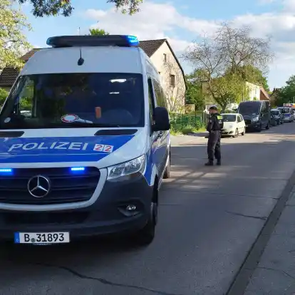 Polizisten sperren eine Straße im Berliner Bezirk Spandau für die Ermittlungsarbeiten.
