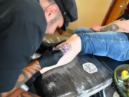 Volle Konzentration bei jedem Stich: Sebastian Wolf tätowiert in seinem Nordenhamer Tattoo-Studio das FKV-EM-Logo auf die Haut von Frank Helmerichs.