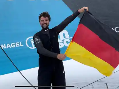 Im Ziel gute 100 Seemeilen vor New York schwenkt der zweitplatzierte Boris Herrmann aus Oldenburg freudestrahlend eine Deutschland-Fahne