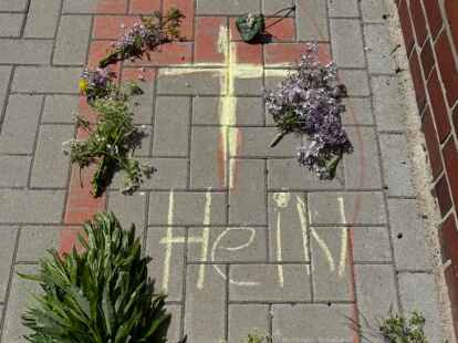 An seinem Stammplatz bei der Grundschule haben die Kinder mit Kreide seinen Namen gemalt und Blumen niedergelegt.