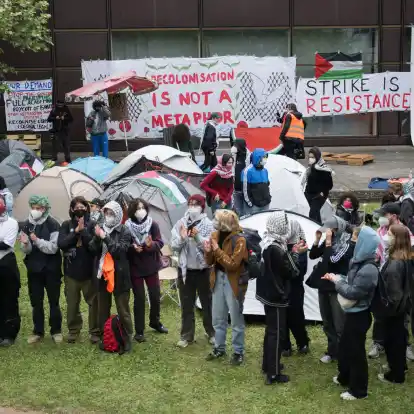 Teilnehmerinnen und Teilnehmer stehen während einer propalästinensischen Demonstration der Gruppe «Student Coalition Berlin» auf dem Theaterhof der Freien Universität Berlin.