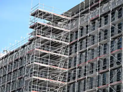 Ein Gerüst steht auf einer Baustelle an einem Rohbau eines Bürogebäudes. An diesem Montag wird Baugewerbe in Niedersachsen gestreikt.