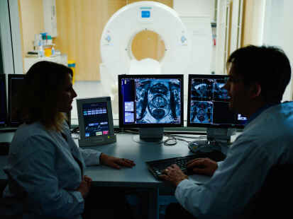 Symbolfoto:  Eine Mitarbeiterin und ein Mitarbeiter  betrachten in einem Kontrollraum des Deutschen Krebsforschungszentrum (DKFZ) auf einem Monitor das Querschnittsbild einer Prostata.