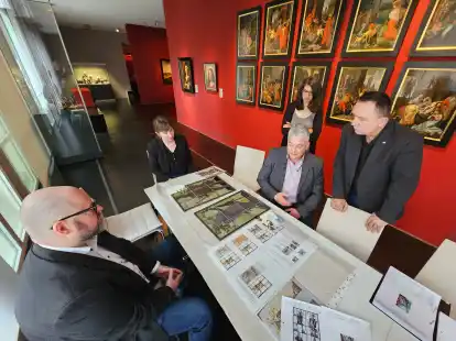 Dr. Stefan Oidtmann von der gleichnamigen Glasmalerei-Werkstatt (Bildmitte, sitzend), erl&auml;utert (v.l.) Michael Engels, Leiter der &bdquo;Fielmann&ldquo;-Niederlassung in Emden, Dr. Constanze K&ouml;ster von der Museumsf&ouml;rderung der &bdquo;Fielmann Group AG&ldquo; aus Hamburg, Jasmin Alley, Direktorin des Landesmuseums, sowie Gregor Strelow, Vorsitzender von &bdquo;1820 die Kunst&ldquo;, seine Arbeit an den historischen Glasfenstern.