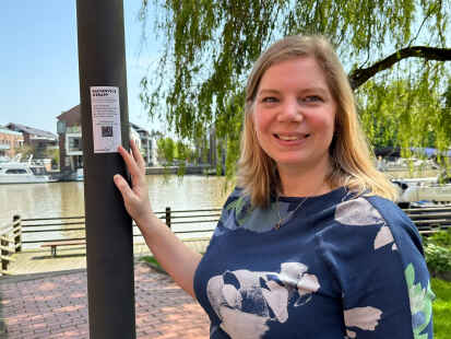 Ella Rösing von der Ostfriesland Tourismus GmbH beim Anbringen der QR-Codes zur Radservice-App.