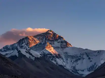 Der Sonnenuntergang färbt den Gipfel des Mount Everest.