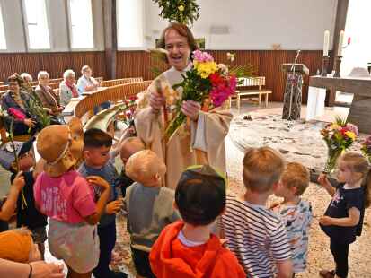 Große Überraschung nach dem Gottesdienst in Bookholzberg: Kinder der St.-Bernhard-Kita überreichen Pfarrer Norbert Lach Blumen zum 35-jährigen Priesterjubiläum.
