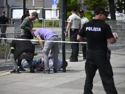 Polizisten nehmen einen Mann fest, nachdem der slowakische Ministerpräsident Fico nach einer Kabinettssitzung in der Stadt Handlova angeschossen und verletzt worden.