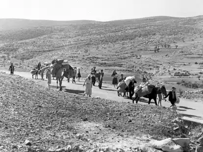 Arabische Flüchtlinge gehen mit ihren Kindern und Habseligkeiten im Gepäck am 9. November 1948 auf einer staubigen Straße von Jerusalem in den Libanon. Die Staatsgründung Israels war 1948 für Hunderttausende von Palästinensern mit Vertreibung und dem Verlust von Heimat verbunden.