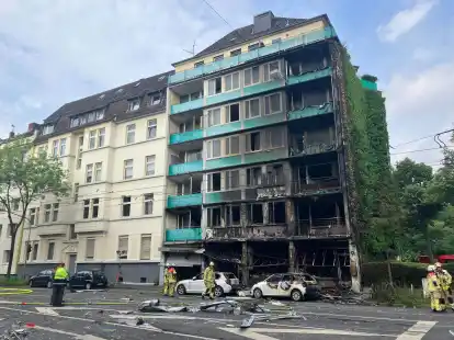 Das Haus, in dem der Brand wütete, in Düsseldorf-Flingern. Auf der Straße liegen Trümmer.