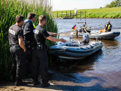 Einsatzkräfte der Polizei fahren bei der Suche nach dem vermissten Arian mit Spürhunden auf Schlauchbooten über die Oste.
