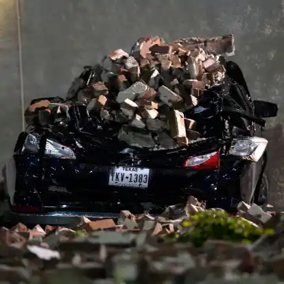 Ein Auto, das von herabfallenden Ziegeln einer umgestürzten Hauswand zerquetscht wurde, steht auf einem Parkplatz in der Innenstadt von Houston.