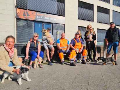 Treffen der morgendlichen Hunderunde am Delft: die beiden Männer in Orange, die Hundeflüsterer Stefan Schütte (l.) und Rolf Janssen (r.) von der Emder Straßenreinigung, im Kreise ihrer vier- und zweibeinigen Freunde.