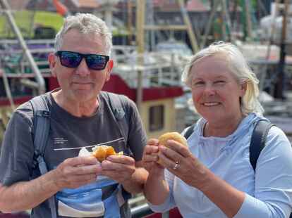 Thomas und Martina Becker, Urlauber aus Westfalen, freuen sich über leckere Fischbrötchen auf den Heringstagen in Hooksiel.