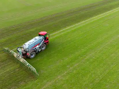 Ein Landwirt bringt mit seinem Gespann G&uuml;lle im sogenannten Schleppschuh Verfahren auf einem Feld aus.