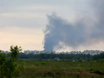 Nach dem Beschuss durch russische Truppen steigt eine Rauchsäule hinter Wohnhäusern in Charkiw auf.