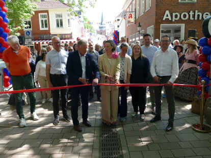 Aurichs Bürgermeister Horst Feddermann (links), Heida Haltermann vom städtischen Kaufmännischen Verein und Hilko Kruse-Edenhuizen von der Strabag übernahmen das obligatorische Zerschneiden roten Bandes.