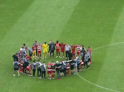 Der D&uuml;sseldorfer Trainer Daniel Thioune (M) spricht auf dem Spielfeld mit seinen Spielern.