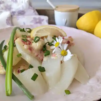 Rote Zwiebelwürfelchen und Gänseblümchen verpassen dem Spargelsalat mit erfrischender Zitrusnote ein paar frühsommerliche Farbtupfer.