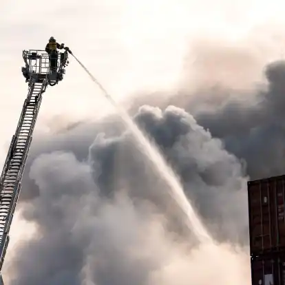 Die Feuerwehr kämpft im Hamburger Hafen gegen das Feuer.