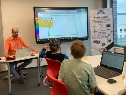 Dozent Bill Gutbier zeigt den Drittklässlern der Grundschule Butjadingen, wie sie am Rechner ihre eigenen Schlüsselanhänger für den 3D-Druck entwerfen.