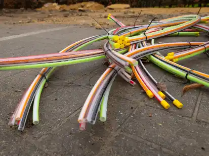 Glasfaserkabel, die in einem Wohngebiet verlegt werden, liegen auf dem Boden.