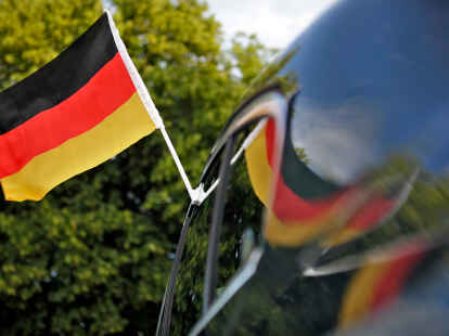 Eine Deutschland-Flagge ist an einem Auto befestigt. Polizisten in Niedersachsen sollen während der Fußball-EM keine schwarz-rot-goldenen Flaggen an ihren Fahrzeugen befestigen.