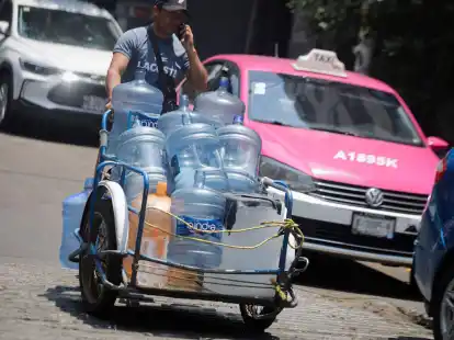 Ein Mann geht mit leeren Wasserkanistern durch eine Straße in Mexiko-Stadt. In 27 der 32 Bundesstaaten in Mexiko liegen die Temperaturen bei mehr als 40 Grad.