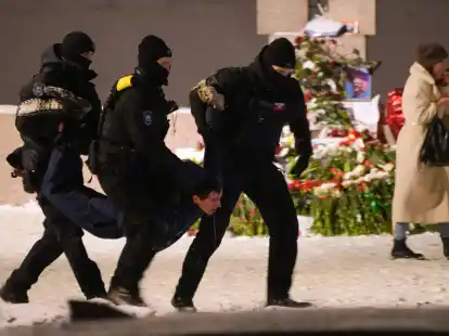 Polizeibeamte halten einen Mann fest, der Blumen zu Ehren von Alexej Nawalny an einem Denkmal f&uuml;r die Opfer der sowjetischen Unterdr&uuml;ckung in St. Petersburg niedergelegt hat.