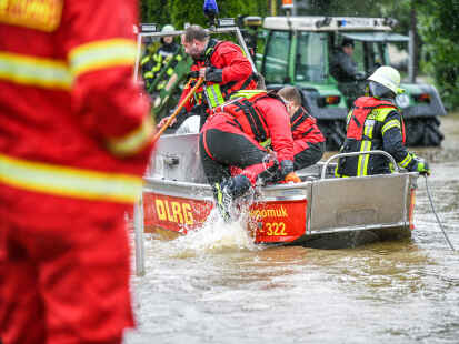 Angehörige der DLRG aus Memmingen sind dabei, Leute aus überschwemmten Wohnungen  zu evakuieren.