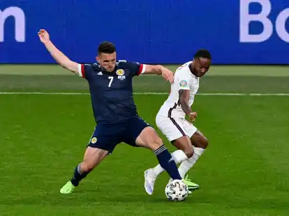 Der Schotte John McGinn (l) ist im Zweikampf vor Raheem Sterling am Ball.