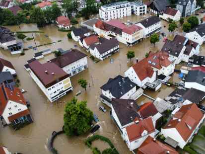 Viele Straßen sind in Babenhausen im bayerisch-schwäbischen Landkreis Unterallgäu überflutet (Aufnahme mit einer Drohne). Das Wasser läuft in die Keller der Häuser.