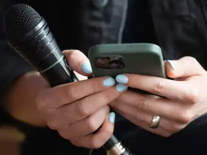 Klimaschutzaktivistin Luisa Neubauer liest auf dem Deutschen Katholikentag bei einer Podiumsdiskussion Hasskommentare von ihrem Smartphone vor. (Hendrik Schmidt/dpa)