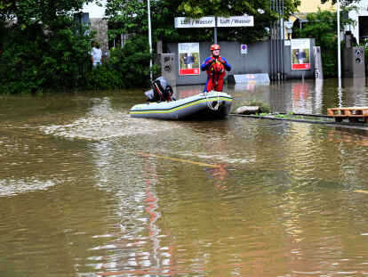 Ein Helfer kommt mit dem Schlauchboot zu einer überschwemmten Tankstelle in Allershausen. Nach starken Regenfällen gibt es in der Region Hochwasser mit Überschwemmungen.