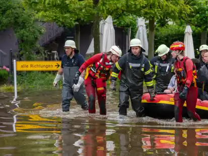 Mit einem Schlauchboot holen Feuerwehr und Wasserretter Anwohner aus ihren &uuml;berfluteten H&auml;usern. Nach dem Starkregen der letzten Tage kam es zu schweren &Uuml;berschwemmungen in der Region. +++ dpa-Bildfunk +++