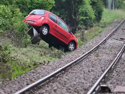 An Bahngleisen in Rudersberg steht ein durch ein Hochwasser weggesp&uuml;ltes Auto.