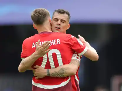 Die Schweizer Michel Aebischer (l) und der Granit Xhaka umarmen sich nach dem Spiel.