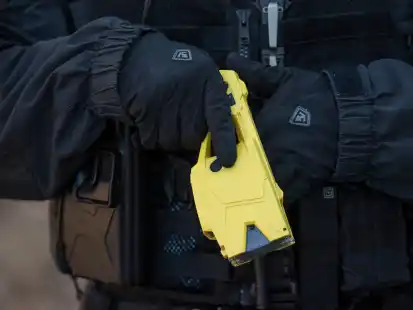 Ein Polizeibeamter h&auml;lt einen Taser in der Hand. In Bremen d&uuml;rfen nun auch Beamte der Bereitschaftspolizei Elektroschockpistolen nutzen. (Symbolbild)