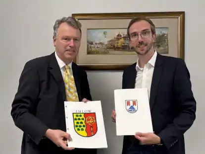 Die B&uuml;rgermeister Hendrik Schulz (Moormerland, rechts) und Arno Ulrichs (Ihlow, links) tauschten im Ihlower Rathaus die Zweckvereinbarung zur gemeinsamen Dorfentwicklung aus.