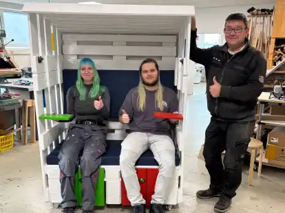 Uwe Esser, handwerklicher Leiter der VHS Jugendwerkstatt, pr&auml;sentiert gemeinsam mit Teilnehmern des VHS-Jugendwerkstattprojektes den au&szlig;ergew&ouml;hnlichen Strandkorb, den es zu ersteigern gilt.