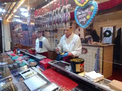 Die F&uuml;llung, die unter Anderem aus Pistazien, Engelshaar und Pistaziencreme besteht, wird vorsichtig in die Form gef&uuml;llt.