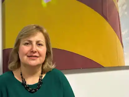 Andira Eibo steht vor einem Bild des Pilsumer Leuchturms. &bdquo;Ich liebe die Nordsee&ldquo;, sagt die geb&uuml;rtige Kurdin.