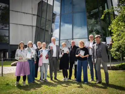 Zeigen stolz das neue Programmheft der Spielzeit 2025/26: Gesine Geppert (von links), Petra Bohlken, Milena Paulovics, Telse Hahmann, Georg Heckel, Anna Neudert, Reinar Ortmann, Hanna Puka, Stefan Schmidt und Matthias Grön