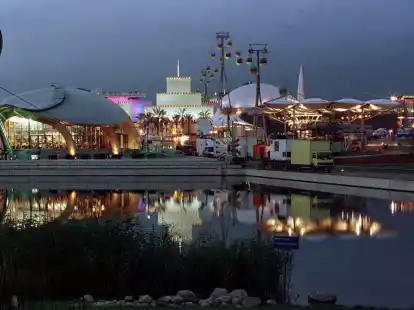 Die Pavillons des Ostgel&auml;ndes spiegeln sich auf der Weltausstellung Expo 2000 in Hannover in einem See. Links der Postpavillon, der Pavillon der Hoffnung in der Form eines Wals, dahinter violett leuchtend der monegassische Pavillon, das W&uuml;stenfort der Vereinigten Arabischen Emirate, unter der Seilbahn mit der wei&szlig;en Kuppel der italienische und links neben dem Riesenrad der Pavillon Estlands. Archivfoto: Rainer Jensen/dpa