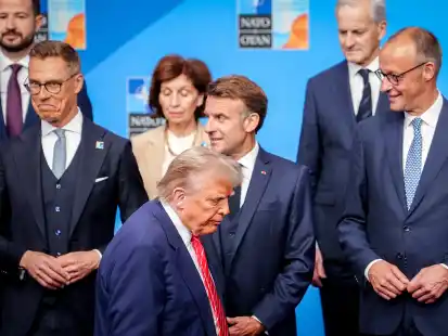US-Präsident Donald Trump geht beim Familienfoto beim Nato-Gipfel an Alexander Stubb (l-r), Präsident von Finnland,, Frankreichs Präsident Emmanuel Macron und Bundeskanzler Friedrich Merz (CDU) vorbei. Die 32 Staats- und Regierungschefs der Nato-Staaten treffen sich hier zu einem zweitägigen Gipfel. Themen des Gipfels sind die Erhöhung der Verteidigungsausgaben, der russische Angriffskrieg gegen die Ukraine sowie die Lage im Nahen Osten nach den US-Angriffen auf iranische Atomanlagen.