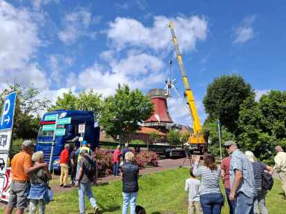 Zahlreiche Menschen verfolgten das Manöver am Donnerstag. Zunächst bekam die Rote Greetsieler Mühle ihre Kappe zurück und dann die Windrose. Später sollten noch die neuen Stahlruten folgen.