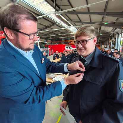 Feuerwehrmann Lukas Smidt-Hubert (rechts) bekam als erster von 54 Einsatzkräften am Donnerstag eine Ehrennadel des Landes Niedersachsen – fürs Foto stellvertretend von Oberbürgermeister Tim Kruithoff persönlich angesteckt. Beim Dezemberhochwasser 2023 hatten Emder Helfer viele Einsätze zwischen Ostfriesland und Oldenburg bewältigt.