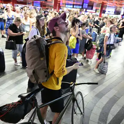 Passagiere sitzen in der Halle des Prager Hauptbahnhofs wähtrend eines Stromausfalls.  Ein Stromausfall hat am Freitag große Teile Tschechiens und der Millionenmetropole Prag lahmgelegt.