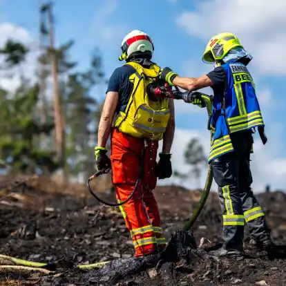 Mit Löschrucksäcken gehen die Feuerwehrleute etwa gegen Glutnester vor.